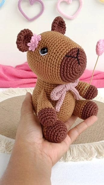 Capivara de crochê marrom com laço rosa